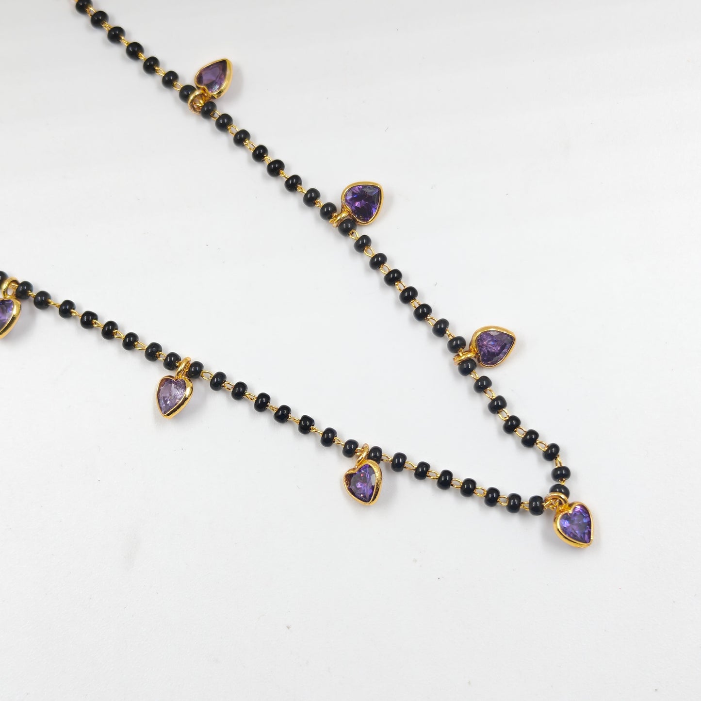 Black beads with drop and heart pattern in purple