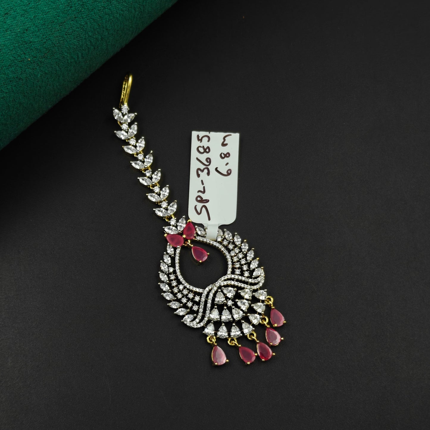 36855 Leaf design maangtikka with red stones and white CZ crystals