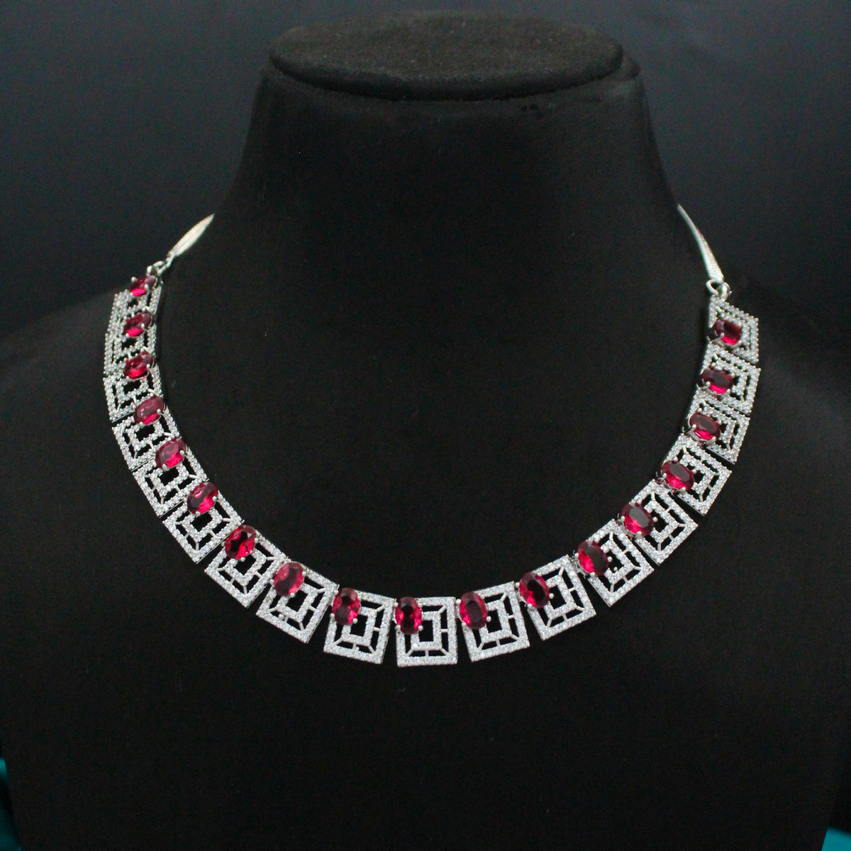 Close view of red square stones on a platinum necklace set