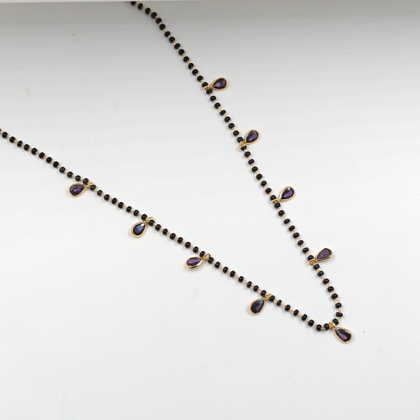 Black beads with drop pattern in purple