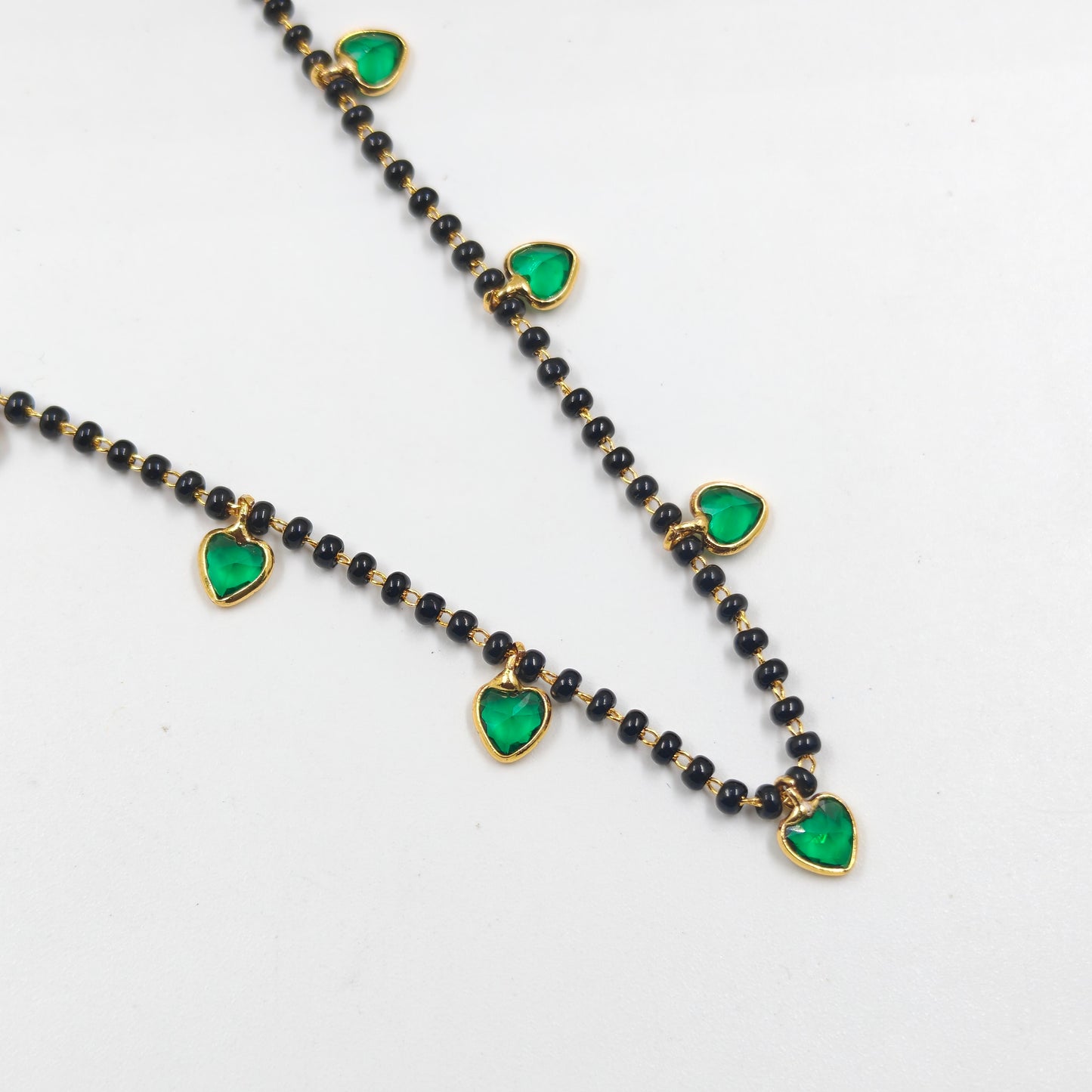 Black beads with drop and heart pattern in green