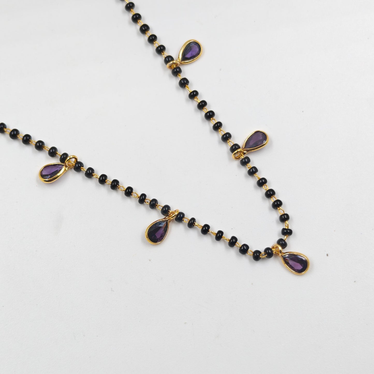 Black beads with drop pattern in purple